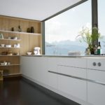 Бял дизайн на кухня на панорамен фон на прозореца