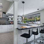 Design av ett vitt kök i det inre av ett rymligt hus med en terrass