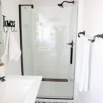 חדר אמבטיה לבן קטן עם דפוסי רצפה