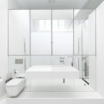 חדר אמבטיה לבן עם קיר מראה
