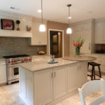 Beige kjøkken med hvite møbler.