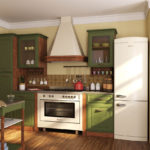 Baltas šaldytuvas virtuvės interjere su žaliu komplektu