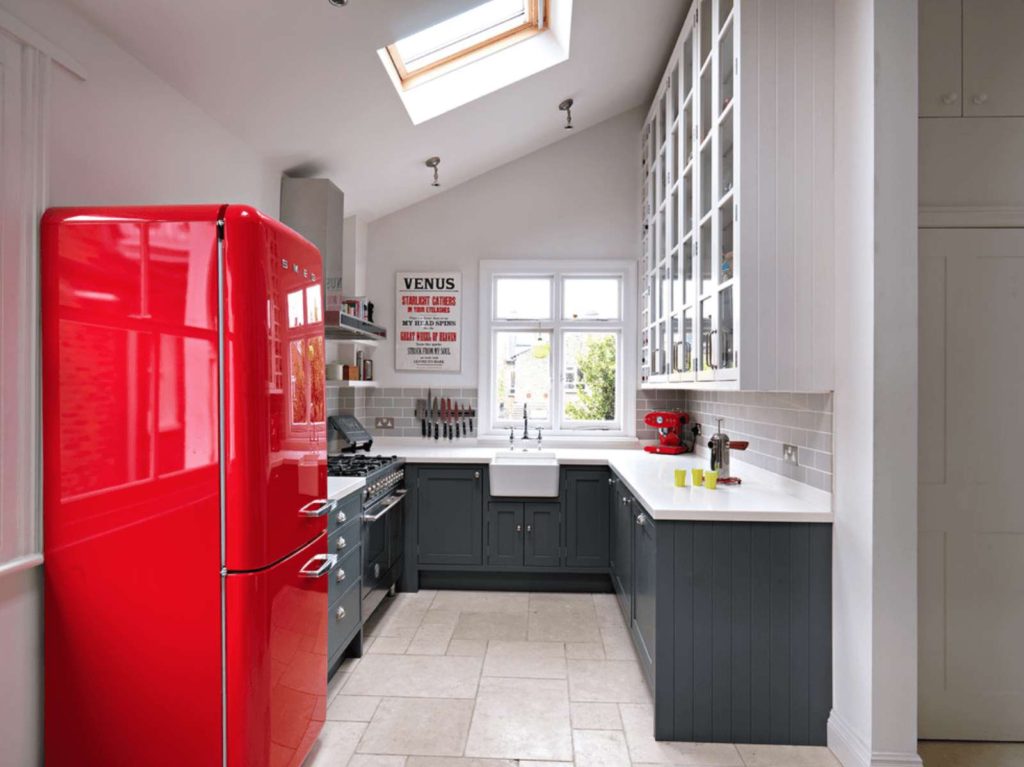 Sarkans ledusskapis baltas virtuves interjerā