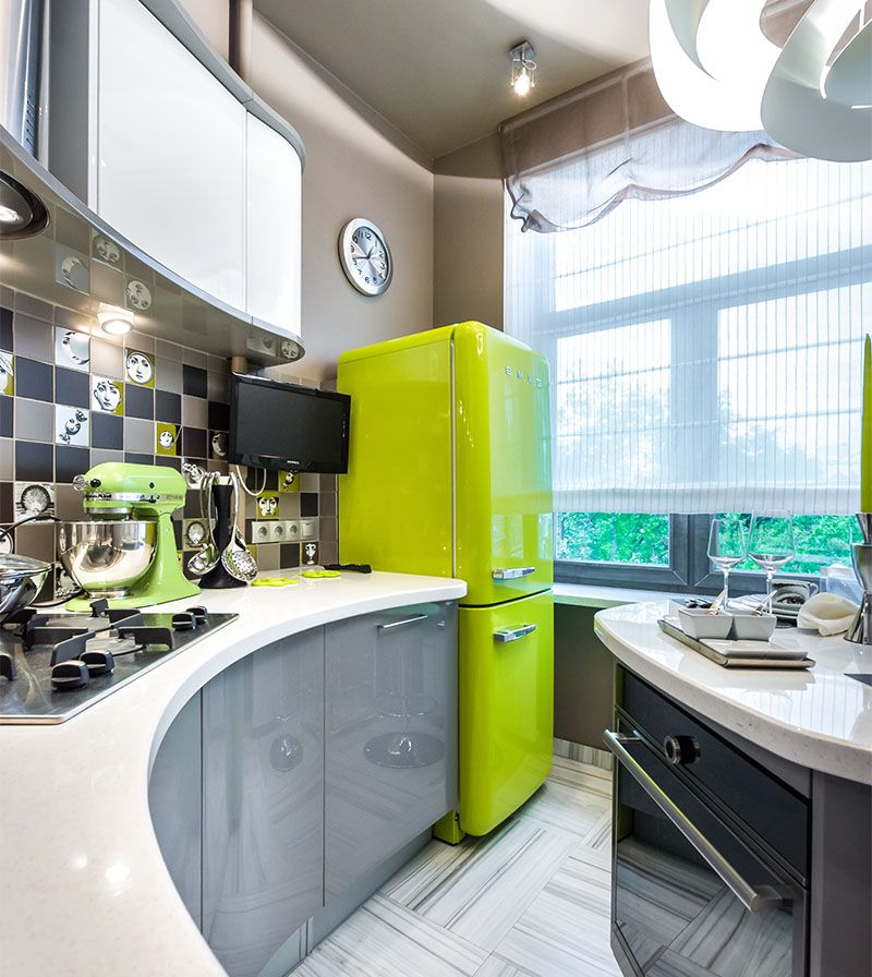 Šviesiai žalios spalvos šaldytuvas virtuvės interjere