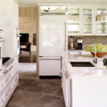 Ledusskapis baltas virtuves interjerā pie ieejas