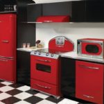 The refrigerator in the interior of the kitchen is red and black