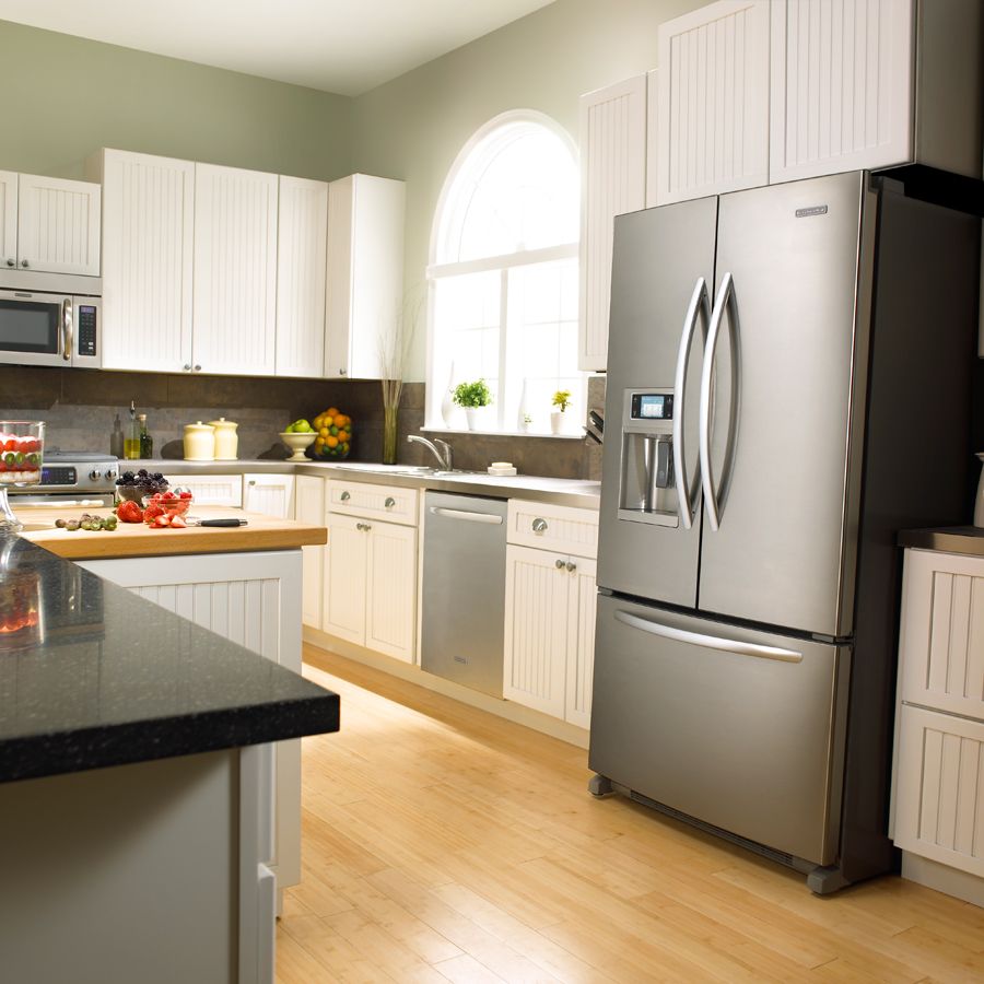Šaldytuvas virtuvės interjere yra sidabro spalvos