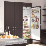 Refrigerator in the interior of the kitchen in the built-in wardrobe