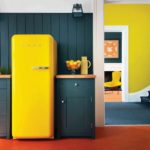 Geltonas šaldytuvas virtuvės interjere retro stiliaus