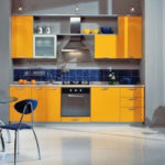 Farebná kombinácia oranžového a tmavomodrého interiéru kuchyne na sivom pozadí