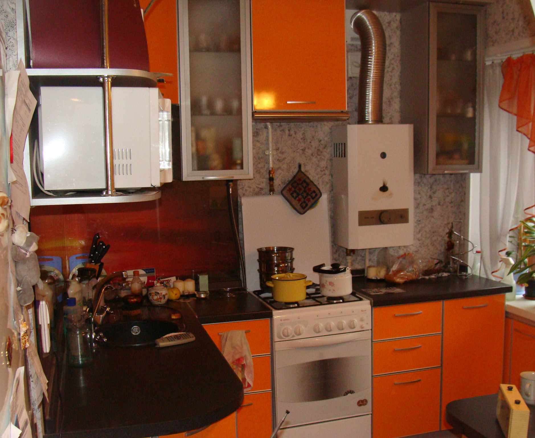 variant d'un interior lluminós de cuina amb una caldera de gas
