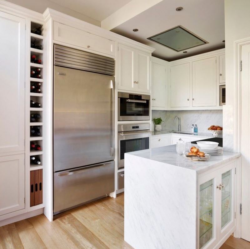 Hvitt kjøkken og rustfritt stål kjøleskap