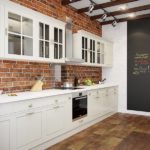 Baltas virtuvės komplektas ant plytų sienos