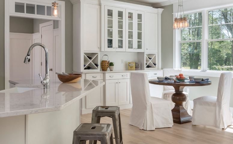 White furniture in the kitchen-dining room of a country house