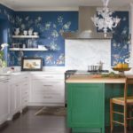 Culoarea albă a dulapurilor de bucătărie, tonul verzui al bazei insulei - reflectată în imprimeul floral al tapetului