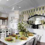 Sniegbaltai virtuvei ar daudziem jūgendstila stila elementiem uzmanības centrā ir akcenta sienas ieviešana, izmantojot trīskrāsu fona attēlus.