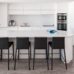 Black bar stools in a white kitchen