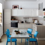 Cadires blaves en una cuina gris