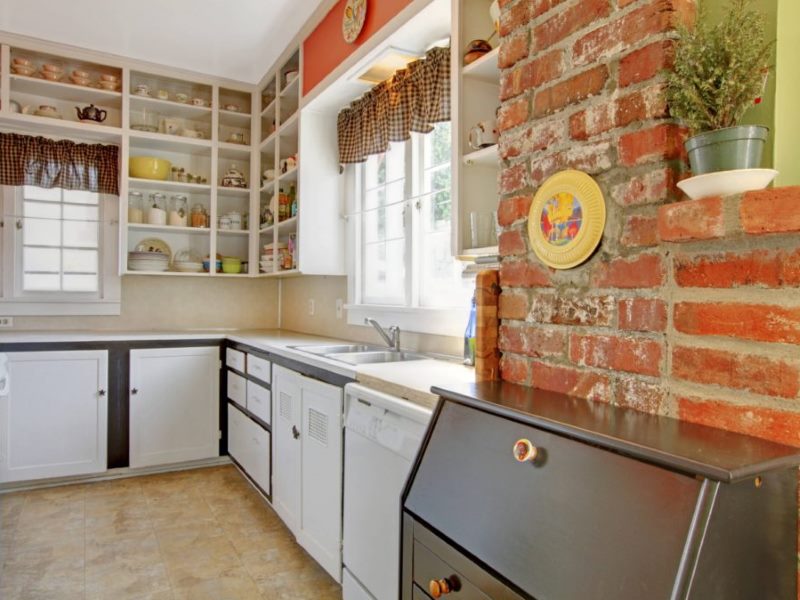 Perete de cărămidă roșie grosieră într-un design mic de bucătărie