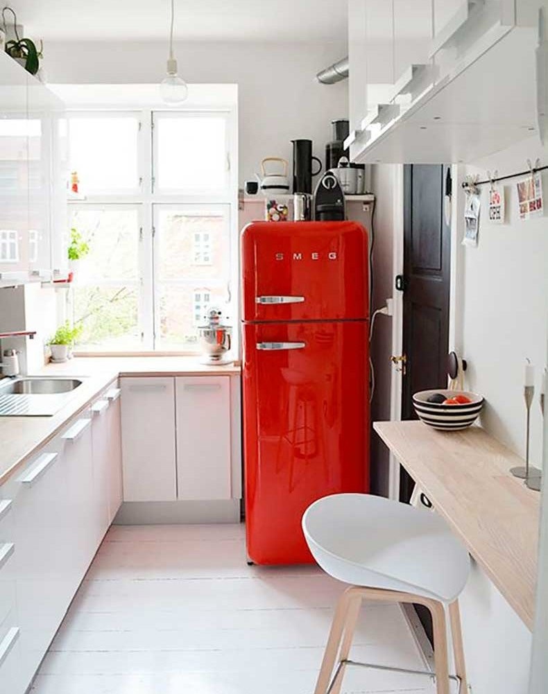 Црвена боја као акцент у кухињи са белим ормарима