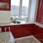 Kırmızı ve pencerede bir lavabo ile yüksek katlı bir binada mutfak