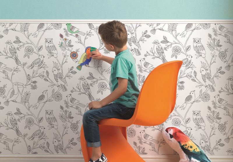 ילד מצייר טפט נייר על קיר חדר ילדים