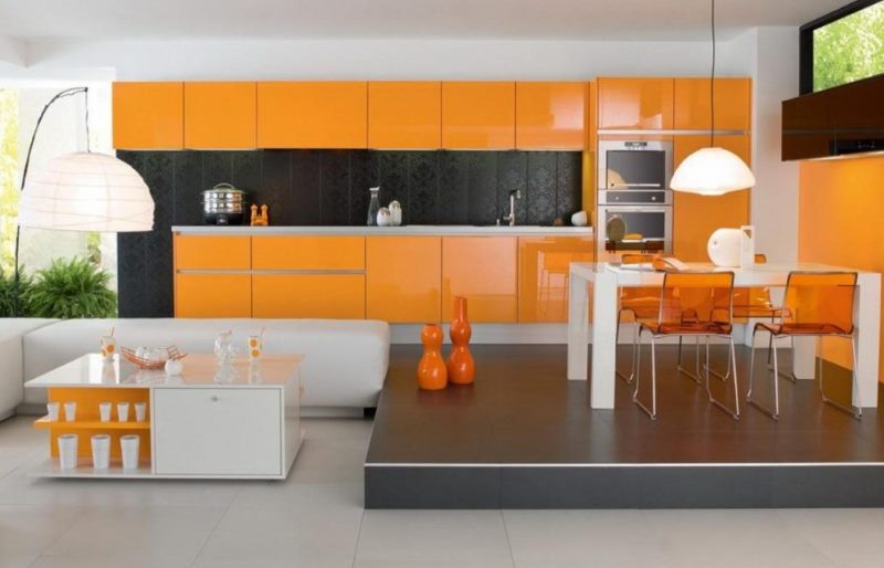 Ryškiai oranžinė virtuvė su valgomojo zona