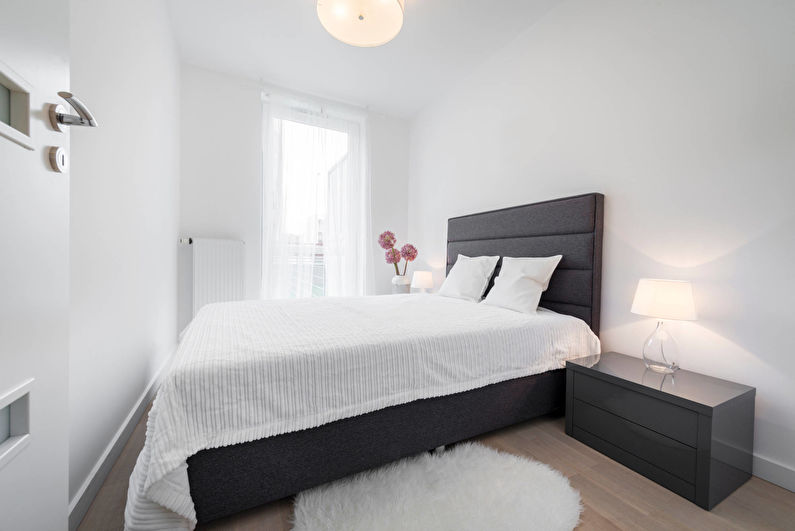 Szare łóżko w białej sypialni o powierzchni 10 metrów kwadratowych