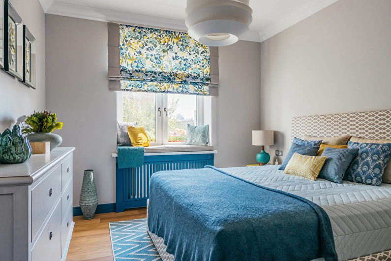 غطاء سرير أزرق في غرفة نوم مع جدران رمادية