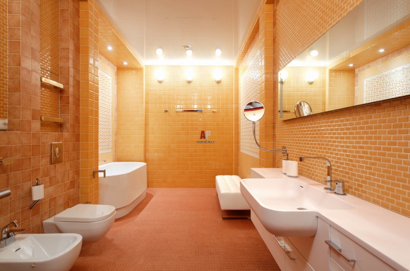 חדר אמבטיה מוארך עם שירותים כתומים
