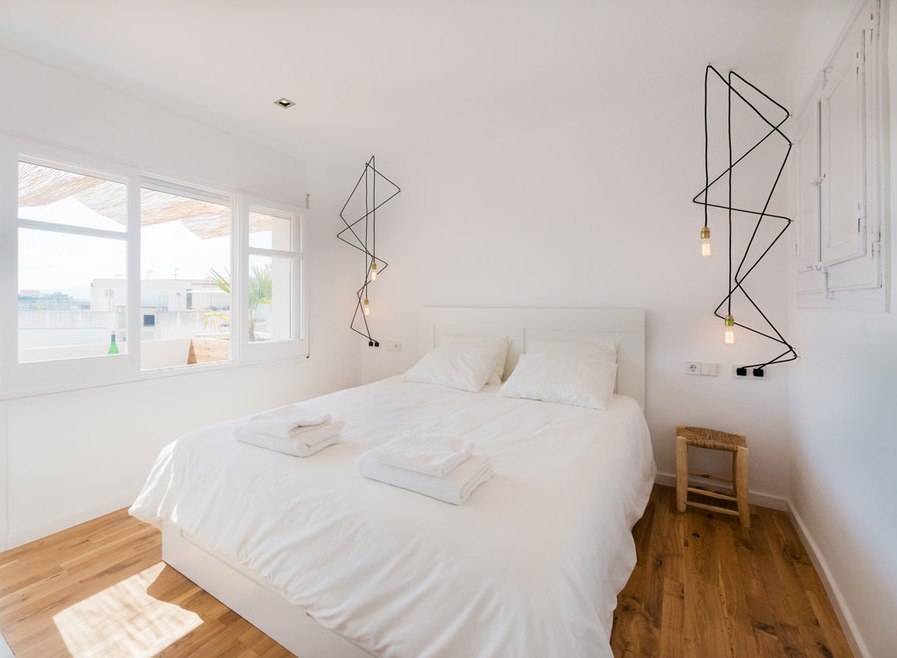 إضاءة أصلية في غرفة نوم بيضاء بأسلوب بسيط.