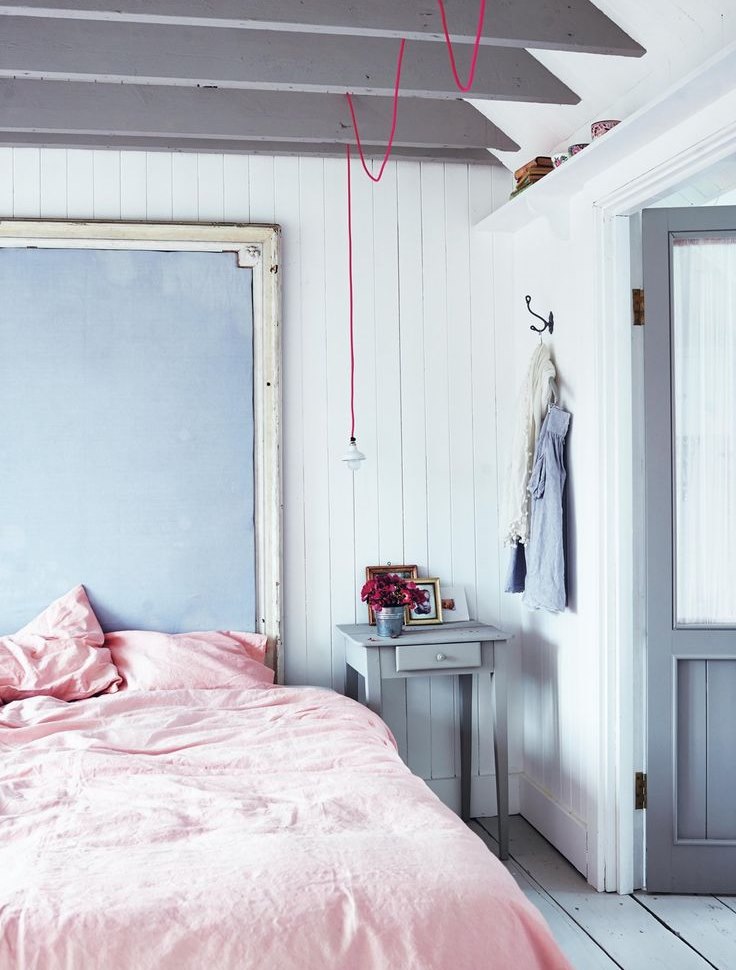 غطاء سرير وردي في غرفة نوم مع جدران زرقاء