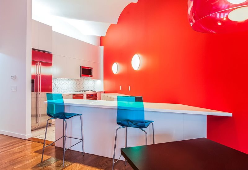 Bức tường màu đỏ trong nhà bếp với đồ nội thất màu trắng