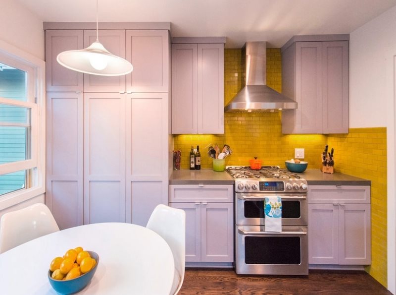 Kompaktiškas virtuvės dizainas su geltonu prijuoste