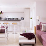 غرفة معيشة ومطبخ مع أريكة باللون الأبيض