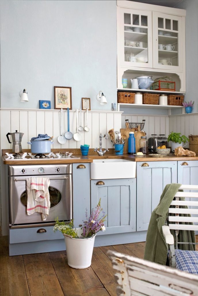Bucătărie rustică cu mobilier albastru deschis.