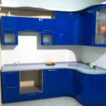 Zila stūra virtuve ar pelēku darba virsmu