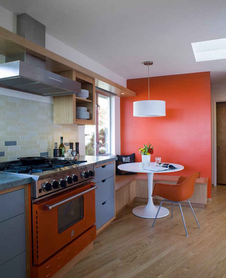 Piso de madeira laminado na cozinha com parede laranja