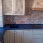 Maza smilškrāsas virtuve ar zilu darba virsmu