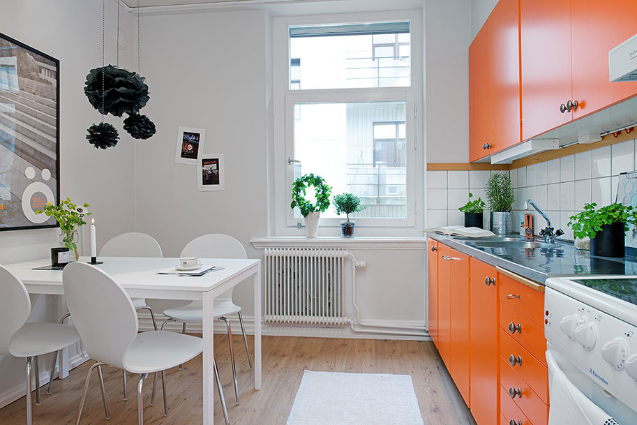 The combination of white and orange in the interior of the kitchen