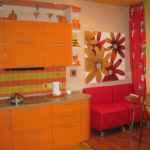 Burgundowa sofa i pomarańczowy zestaw