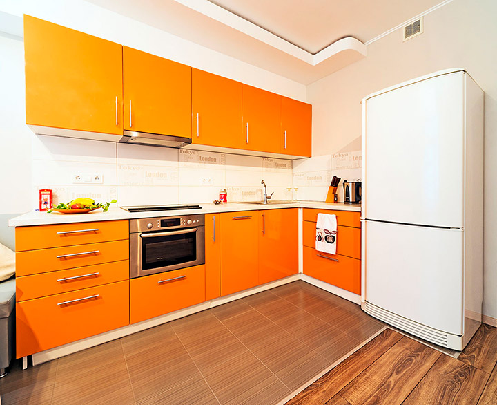 Stūra virtuvē balts divkameru ledusskapis