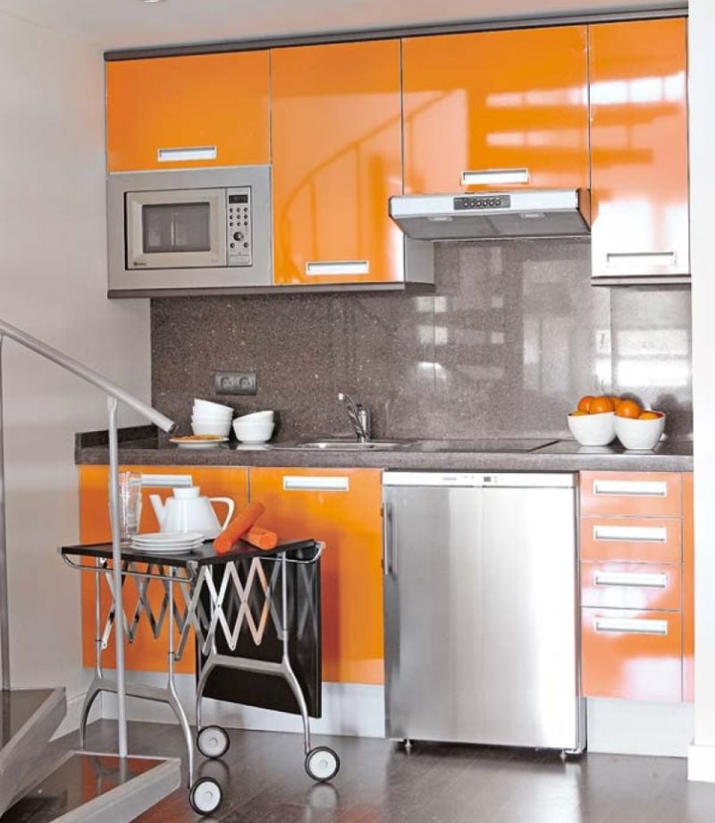 Metāliska un oranža toņa kombinācija virtuves interjerā