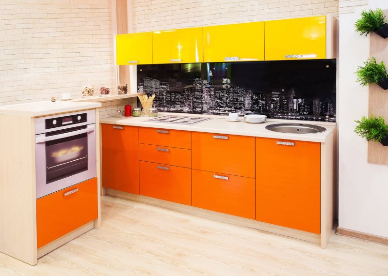 En kombination av gula skåp med orange skåp i köket