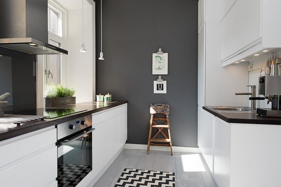 Mobilier alb într-o bucătărie îngustă cu un perete gri