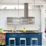 Gaiša un plaša virtuves-viesistaba ar zilām austiņām
