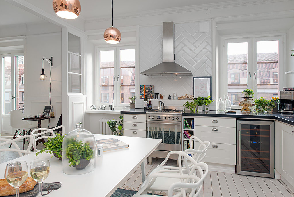 Rummeligt køkken med hvide skandinaviske møbler