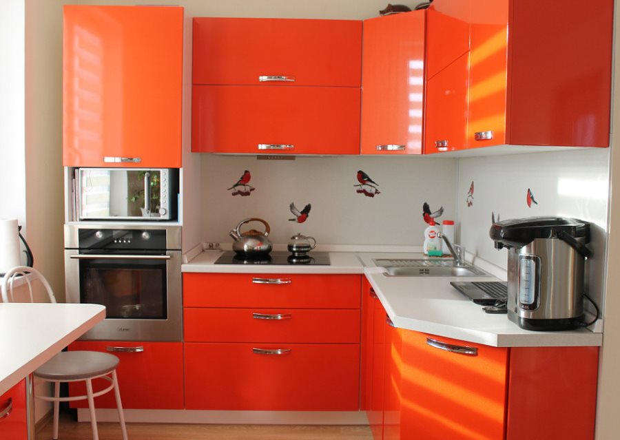 مطبخ صغير مع مجموعة من التصميم على شكل حرف L