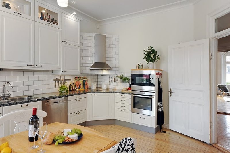 Interior of a bright kitchen with a stove in the corner of the room