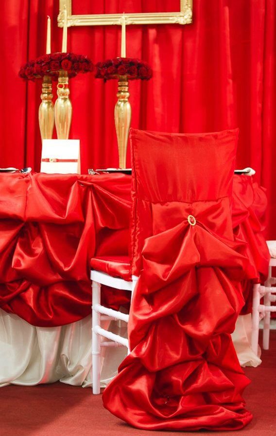 غطاء أحمر مصنوع من الساتان الكريم على كرسي احتفالي
